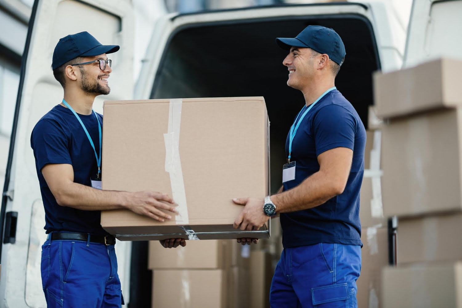 happy-manual-worker-cooperating-while-carrying-cardboard-boxes-delivery-van about-us/delivery-mode